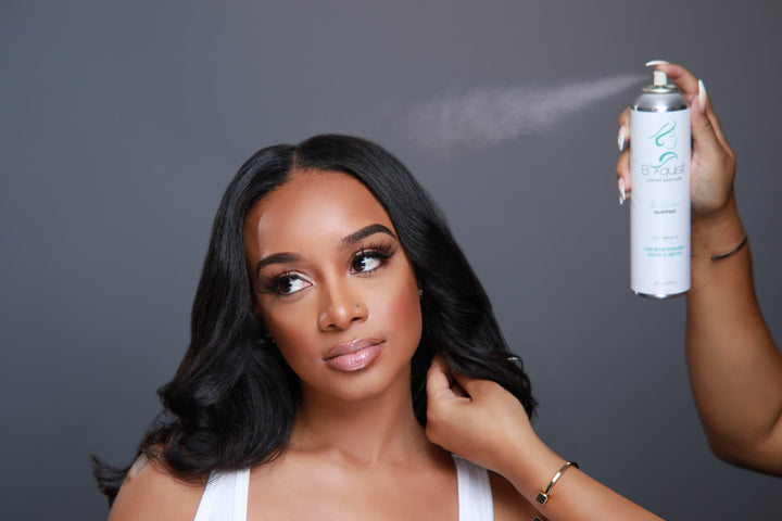 B. Xquisit Hold It hairspray being applied to a finished hairstyle